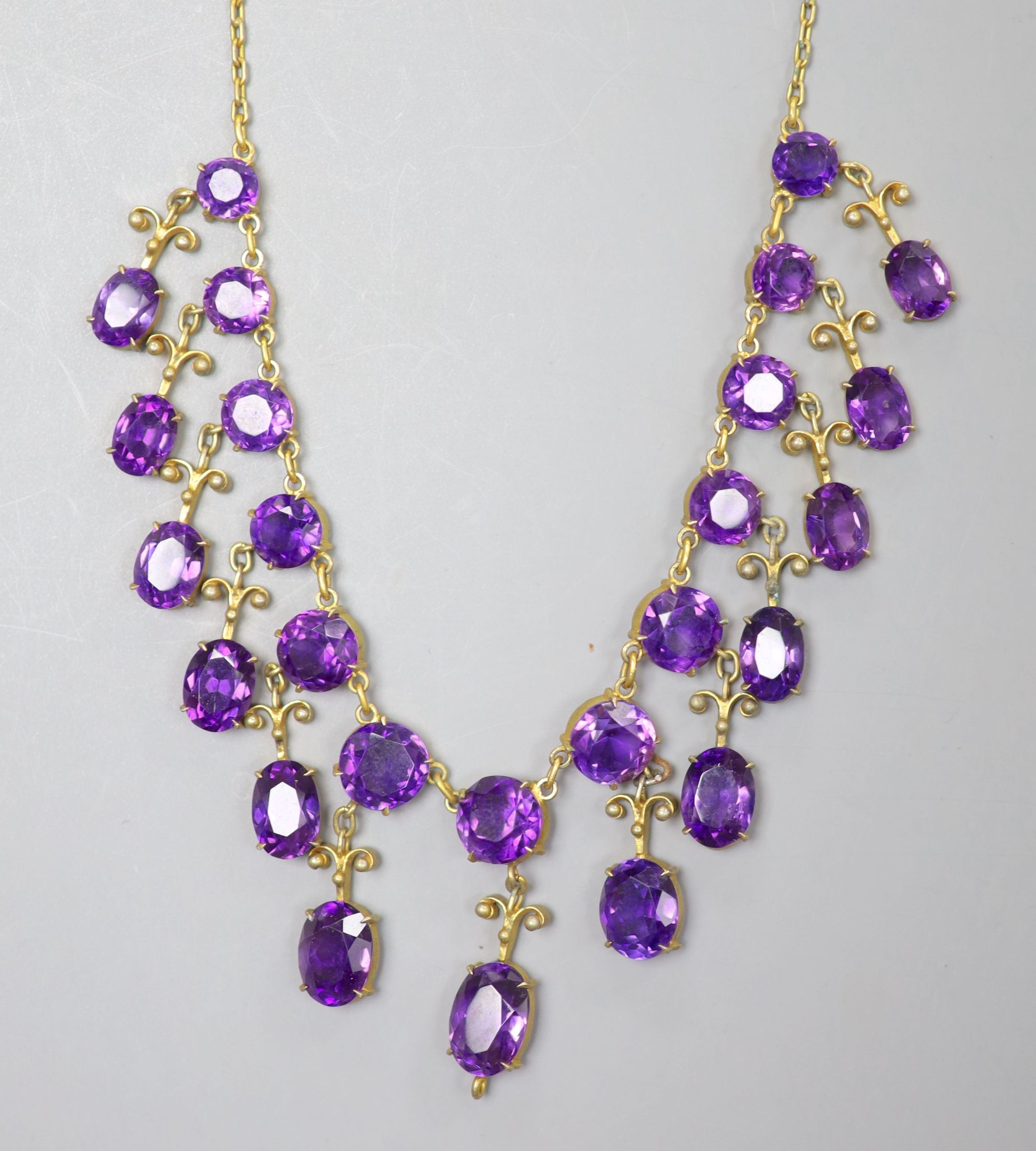 A 19th century gilt metal and oval cut amethyst set drop fringe necklace, 46cm (drop missing from bottom of necklace).